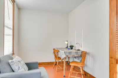 a living room with a table with chairs and a couch at Walk to Washington Park Remote Work-Ready Apt! in Albany