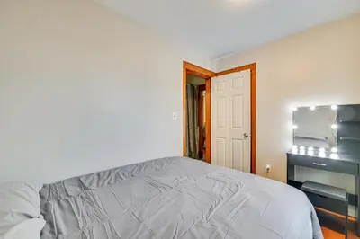 a white bedroom with a bed and a desk at Walk to Washington Park Remote Work-Ready Apt! in Albany