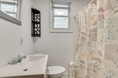 a bathroom with a sink and a shower curtain at Walk to Washington Park Remote Work-Ready Apt! in Albany