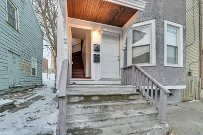 a front door of a house with snow on the steps at Walk to Washington Park Remote Work-Ready Apt! in Albany