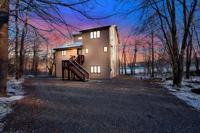 a house with a staircase leading up to it at Lakefront Movie Theater, Hot Tub, Arcade, Boats in Gouldsboro