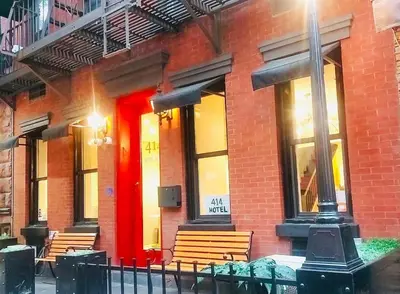 a red brick building with benches in front of it at 414 Hotel in New York