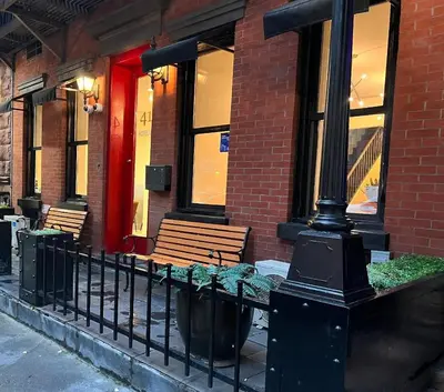 a street light in front of a building with benches at 414 Hotel in New York