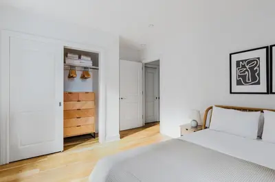 a white bedroom with a bed and a closet at Blueground Midtown gym AC nr Chrysler NYC-1665 in New York