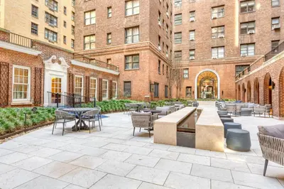 a courtyard with tables and chairs and buildings at Blueground Midtown gym AC nr Chrysler NYC-1665 in New York
