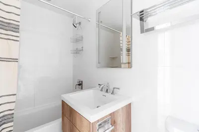 a white bathroom with a sink and a mirror at Midtown East 1br w elevator nr transport NYC-1249 in New York