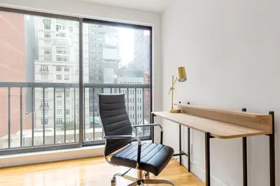 a desk and chair in a room with a large window at Midtown East 1br w elevator nr transport NYC-1249 in New York
