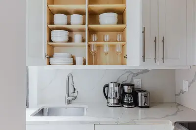 a kitchen counter with a sink and white cabinets at Blueground Boerum Hill gym wd nr sports NYC-1573 in New York