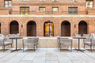 a patio with tables and chairs in front of a brick building at Blueground Boerum Hill gym wd nr sports NYC-1573 in New York