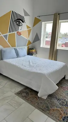 a bedroom with a bed with a geometric wall at Skyline Penthouse in Woodside