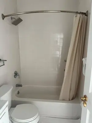 a bathroom with a white tub and a toilet at Skyline Penthouse in Woodside