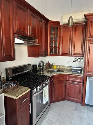 a kitchen with wooden cabinets and a stove top oven at Skyline Penthouse in Woodside