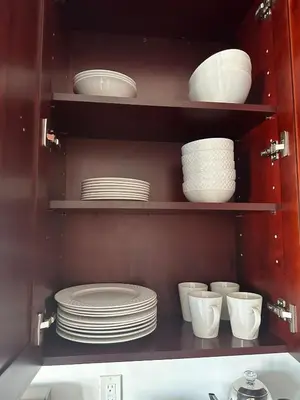 a cabinet filled with white plates and bowls at Skyline Penthouse in Woodside