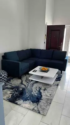a blue couch in a living room with a table at Skyline Penthouse in Woodside