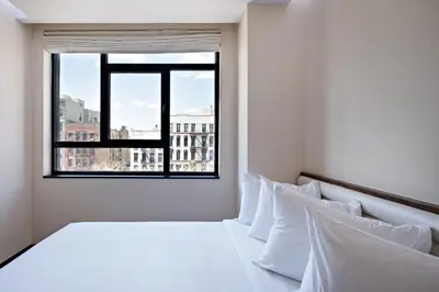 a bedroom with a white bed and a window at Orchard Street Hotel in New York
