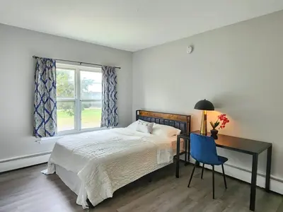 a bedroom with a bed and a desk and a window at Elegant Retreat Where Relaxation Embraces Design in Springfield
