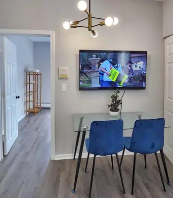 a dining room with a glass table and blue chairs at Elegant Retreat Where Relaxation Embraces Design in Springfield