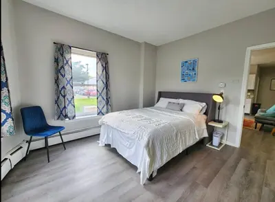 a bedroom with a bed and a chair and a window at Elegant Retreat Where Relaxation Embraces Design in Springfield