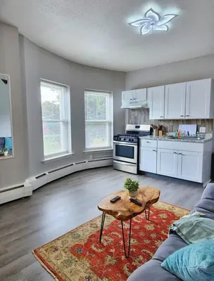 a kitchen with a couch and a table in a living room at Elegant Retreat Where Relaxation Embraces Design in Springfield