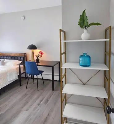 a bedroom with a bed and a desk with a blue chair at Elegant Retreat Where Relaxation Embraces Design in Springfield