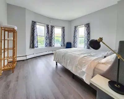 a bedroom with a bed and two windows at Elegant Retreat Where Relaxation Embraces Design in Springfield