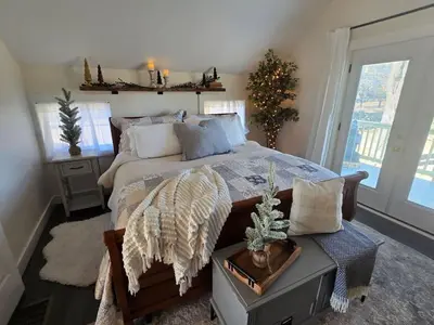 a bedroom with a large bed and a christmas tree at The Jefferson Guest House in Litchfield