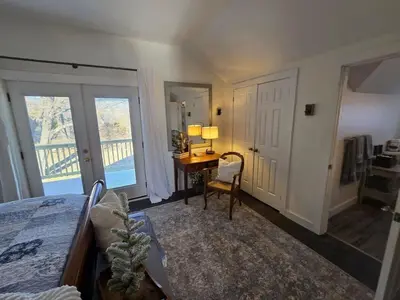 a bedroom with a bed and a desk and a window at The Jefferson Guest House in Litchfield