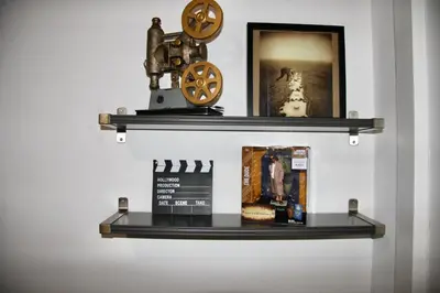 a shelf with books and a clock on a wall at Wooster Square Gems in New Haven