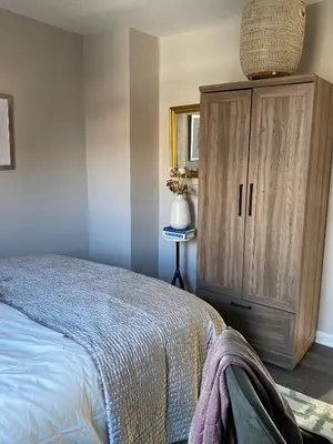 a bedroom with a bed and a wooden cabinet at Wooster Square Gems in New Haven