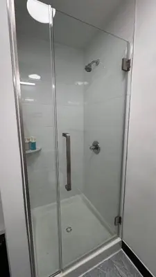 a shower with a glass door in a bathroom at Private Bedroom with Dedicated Bathroom 15mis NYC in West New York