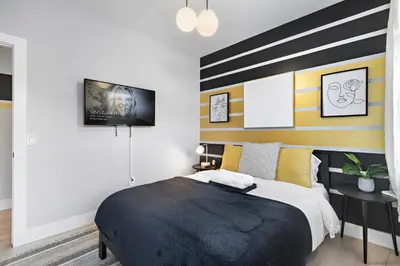 a bedroom with a black and yellow striped wall at 1A Prime Area Near NYC and EWR 98 Walk score in Newark