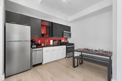 a kitchen with a stainless steel refrigerator and a table at 1C - Ask About 20Off - Sleeps 5 - Airport 8min - NYC 30min in Newark