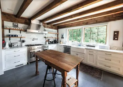 a kitchen with white cabinets and a wooden table at Charming 6 Bdrm Countryside Stay, Sauna and HotTub in North Egremont