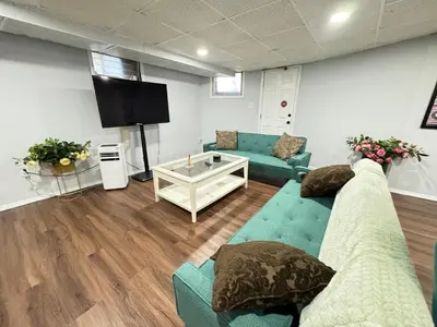 a living room with couches and a flat screen tv at Cozy 1 bedroom close to NYC with private bar in North Bergen