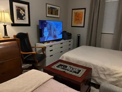 a bedroom with two beds and a television on a dresser at Cozy Brooklyn Home, Private Room in Host Shared Apartment in Brooklyn