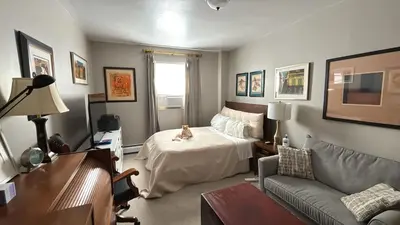 a bedroom with a bed with a cat sitting on it at Cozy Brooklyn Home, Private Room in Host Shared Apartment in Brooklyn
