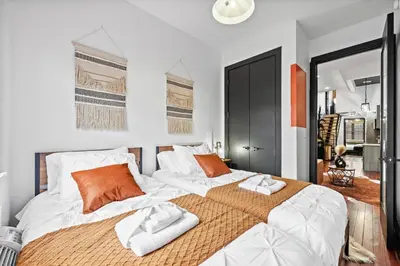 a bedroom with a large bed with towels on it at Rustic Chic 4BR for Groups - Bushwick's Finest Stay in Brooklyn