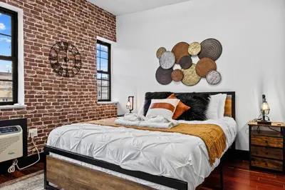 a bedroom with a bed with a brick wall at Rustic Chic 4BR for Groups - Bushwick's Finest Stay in Brooklyn