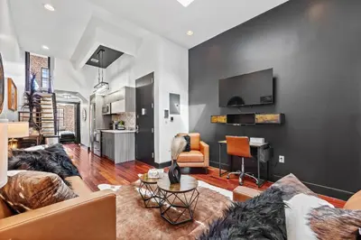 a living room with a couch and a table at Rustic Chic 4BR for Groups - Bushwick's Finest Stay in Brooklyn