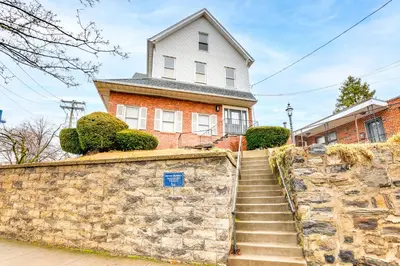 a brick house with a stone wall and stairs at Centrally Located and Pet Friendly Yonkers Studio! in Yonkers
