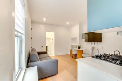 a kitchen and living room with a couch and a stove at Centrally Located and Pet Friendly Yonkers Studio! in Yonkers