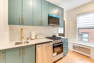a kitchen with blue cabinets and a stove top oven at Centrally Located and Pet Friendly Yonkers Studio! in Yonkers