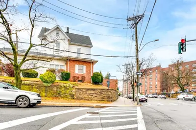 a white car stopped at a traffic light in front of a house at Centrally Located and Pet Friendly Yonkers Studio! in Yonkers