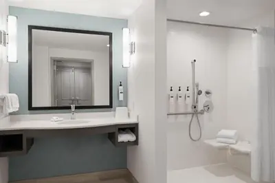 a bathroom with a sink and a shower with a mirror at Hilton Garden Inn Lenox Pittsfield in Pittsfield