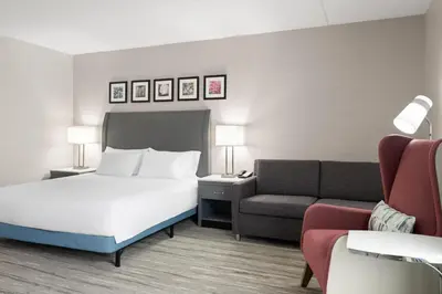 a hotel room with a bed and a couch at Hilton Garden Inn Lenox Pittsfield in Pittsfield