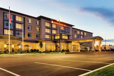 an exterior view of a hotel with a parking lot at Hilton Garden Inn Lenox Pittsfield in Pittsfield