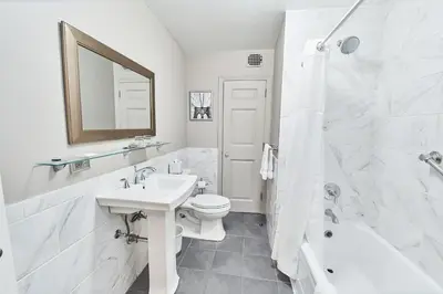 a white bathroom with a sink and a toilet and a tub at 3 West Club in New York