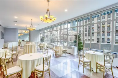 a dining room with tables and chairs and a large window at 3 West Club in New York