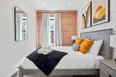 a bedroom with a bed with orange and white pillows at SWJ 4 - 25 Min to Times Sq Save on 2Day Stays in New York