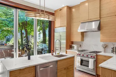 a kitchen with wooden cabinets and a large window at SWJ544FH Huge 6BR 4BA Backyard Access in New York